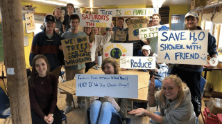 Saint Lawrence students hold various environmental action signs for climate change awareness.